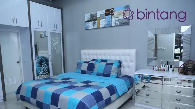 Tempat tidur Fitri Carlina terlihat besar serta bernuansa putih dan biru.