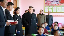 Ekspresi Kim Jong Un saat melihat anak-anak yatim belajar di ruangan kelas Sekolah Dasar Anak Yatim di Pyongyang, Korea Utara (2/2). (AFP Photo / KCNA VIA KNS / STR)