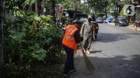Warga menyapu jalan saat razia masker di kawasan Karang Tengah Lebak Bulus, Jakarta, Selasa (24/11/2020). Denda tersebut terkumpul sejak penerapan Peraturan Gubernur Nomor 51 tahun 2020 pada Juni 2020 lalu. (Liputan6.com/Faizal Fanani)