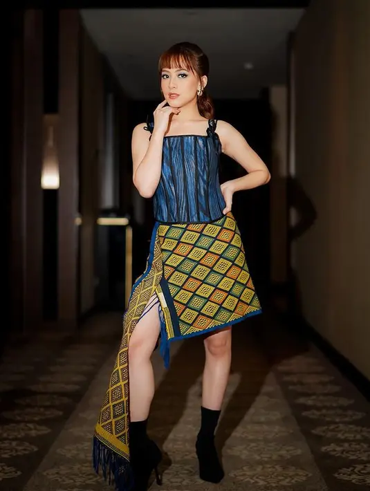 Saat Gala Premiere film Keluarga Cemara 2, Zara Adhisty mengenakan tenun sebagai outfitnya. Ia memadukan korset dengan tali spagetti yang dipadukan dengan asimetris rok dari tenun dengan warna kontras. (instagram/zaraadhsty)