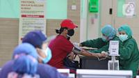 Petugas memeriksa kesehatan penerima vaksin covid-19 di RSUD Pasar Minggu, Jakarta, Selasa (25/8/2021). Vaksin Moderna di Jakarta diberikan untuk warga yang tidak bisa menggunakan vaksin AstraZenecca dan Sinovac berdasarkan surat keterangan dari fasilitas kesehatan. (Liputan6.com/Herman Zakharia)