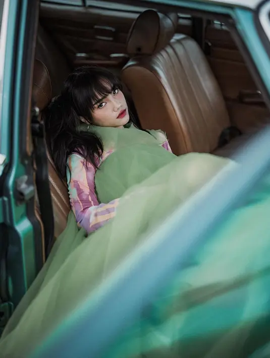 Ia mengenakan long sleeve top multi-colour yang dipadukan dengan halter tulle dress bervolume warna hijau @stevenhuang_official.  [@winstongomez]