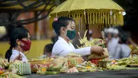 Seorang wanita bersiap berdoa untuk merayakan festival keagamaan Galungan di Pura Jagat Natha di Denpasar, di pulau Bali (16/9/2020). Galungan dirayakan umat Hindu di Bali sebagai hari kemenangan Dharma (Kebaikan) melawan Adharma (Keburukan). (AFP Photo/Sonny Tumbelaka)