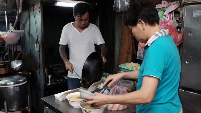 Mantan gangster Taiwan, Yen Wei-shun bersama sang ibu menyiapkan mi di kedai usaha keluarganya di pasar tradisional New Taipei City, 4 September 2018. Yen bercerita mengenal kehidupan keras gangster sejak berusia 15 tahun. (SAM YEH/AFP)