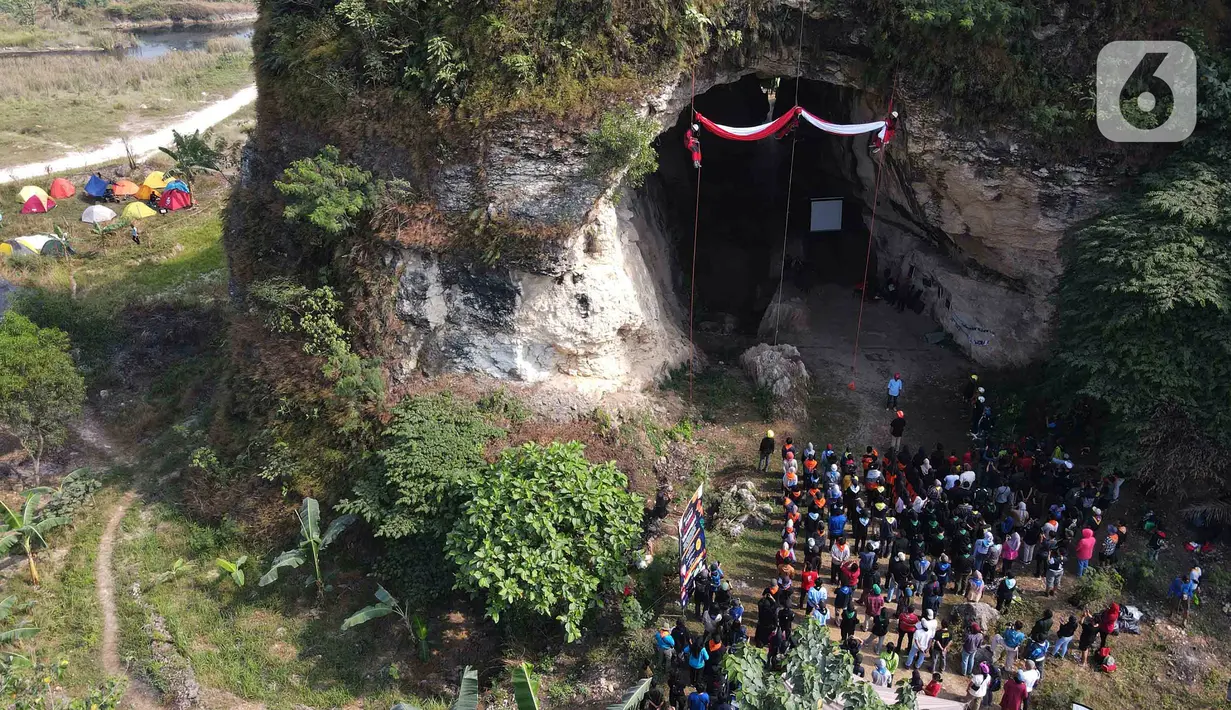 Bendera Merah Putih berukuran 6x4 meter yang dikaitkan dengan tali karmantel dibentangkan pada mulut gua. (merdeka.com/Imam Buhori)