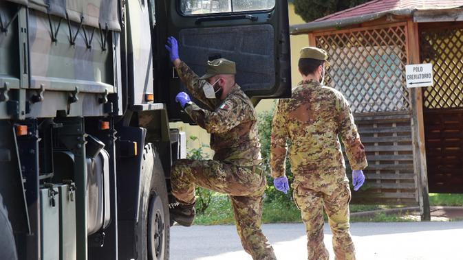 Tentara terlihat di dekat truk militer pembawa jenazah pasien COVID-19 dari Lombardia di Bologna, 31 Maret 2020. Jumlah kematian akibat COVID-19 di Italia pada Selasa (31/3) mencapai 837, sehingga totalnya menjadi 12.428 sejak pandemi itu kali pertama muncul di Italia utara. (Xinhua/Gianni Schicchi)