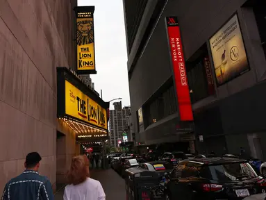 Orang-orang berjalan melewati Theater District di Manhattan, New York City, Kamis (6/5/2021). Gubernur Andrew Cuomo mengumumkan teater Broadway akan dibuka kembali dalam kapasitas penuh mulai 14 September, sejak ditutup Maret 2020 karena pandemi COVID-19. (MICHAEL M. SANTIAGO/GETTY IMAGES VIA AFP)