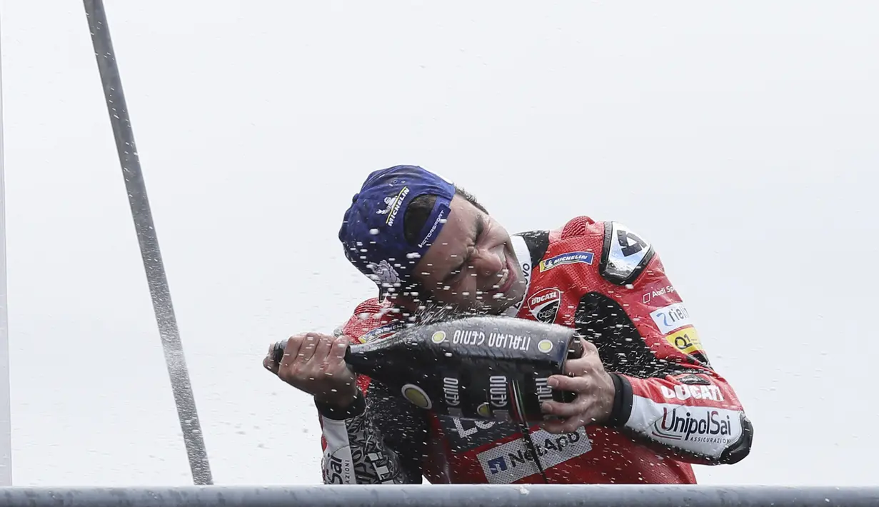 Pembalap Ducati Danilo Petrucci menyemprotkan sampanye saat merayakan kemenangannya pada balapan MotoGP Prancis 2020 di Le Mans, Prancis, Minggu (11/10/2020). Danilo Petrucci menjadi yang tercepat disusul Alex Marquez dan Pol Espargaro. (AP Photo/David Vincent)