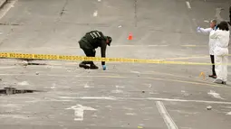 Polisi Kolombia dan ahli forensik memeriksa lokasi ledakan di dekat arena adu banteng Plaza Santamaria di pusat kota Bogota, Minggu (19/2). Hingga saat ini belum ada informasi yang detail terkait ledakan di arena adu banteng itu (AP Photo/Ricardo Mazalan)