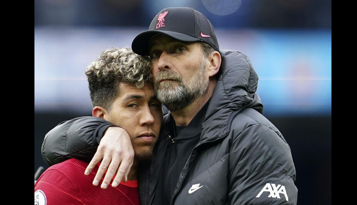 Manajer Liverpool, Jurgen Klopp (kanan) memeluk Roberto Firmino pada akhir pertandingan Liga Inggris antara Manchester City dan Liverpool di Etihad Stadium, 10 April 2022. (AP/Jon Super)