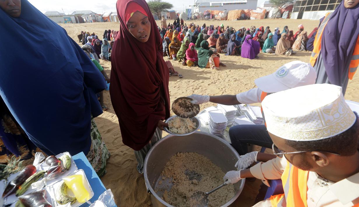 LSM lokal menyiapkan makanan berbuka puasa untuk orang-orang selaam bulan suci Ramadhan di kamp pengungsi internal di pinggiran Mogadishu, Somalia pada Jumat, 24 Maret 2023. (AP Photo/Farah Abdi Warsameh)