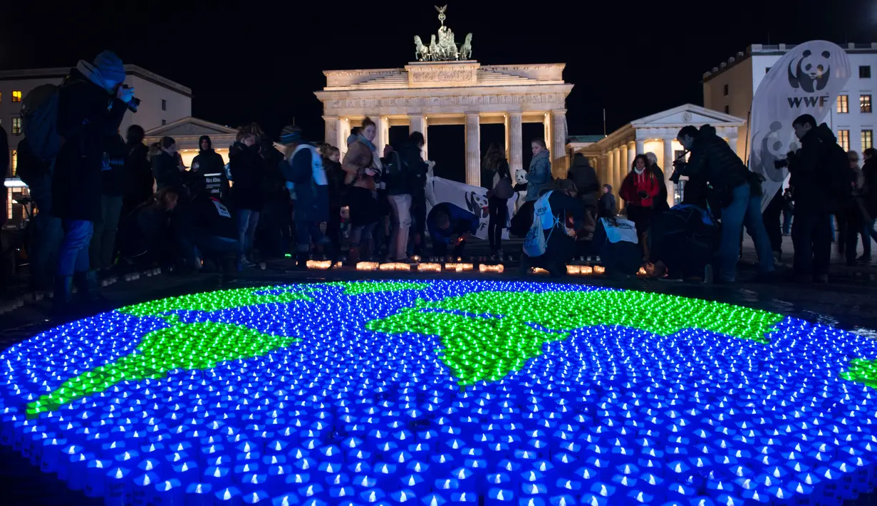 Sejumlah lilin dinyalakan dan dibentuk seperti dunia sebelumnya aksi Earth Hour Internasional di Berlin, Jerman (25/3). Kegiatan ini dilakukan dalam rangka memperingati hari bumi atau lebih dikenal dengan Earth Hour ke-10 atau 2017. (AFP/dpa/Paul Zinken)