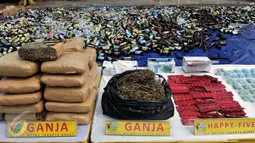 Sejumlah barang bukti kejahatan diperlihatkan di halaman Mapolsek Palmerah, Jakbar, Senin (15/6). Barang bukti yang dimusnahkan berupa 10.286 botol miras, 561 kg ganja, 1,4 kg sabu, 7.668 butir ekstasi, 1.000 butir psikotropika. (Liputan6.com/Johan Tallo)