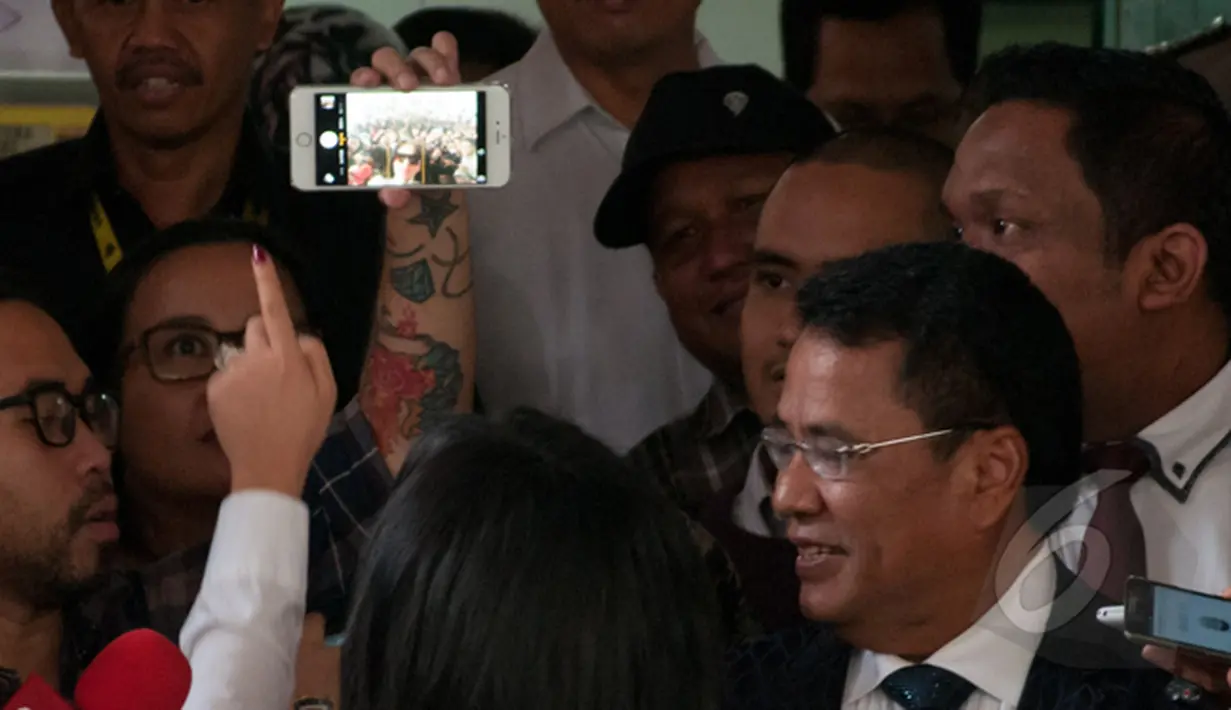Syahrini meminta kepada seorang lelaki untuk memfoto dirinya melalui ponsel miliknya saat di Bareskrim, Jakarta, Senin (2/3/2015). Ia diperiksa terkait kasus Ketua KPK nonaktif Abraham Samad dan Feriyani Lim. (Liputan6.com/Yoppy Renato)