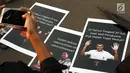 Aktivis yang tergabung dalam Jaringan Solidaritas Korban untuk Keadilan memotret poster saat aksi Kamisan di depan Istana Negara, Jakarta, Kamis (25/7/2019). Aksi Kamisan ke-594 mengangkat tema '23 Tahun Tragedi 27 Juli Saat Jadi Penguasa Kok Malah Tidak Peduli?'. (Liputan6.com/Helmi Fithriansyah)