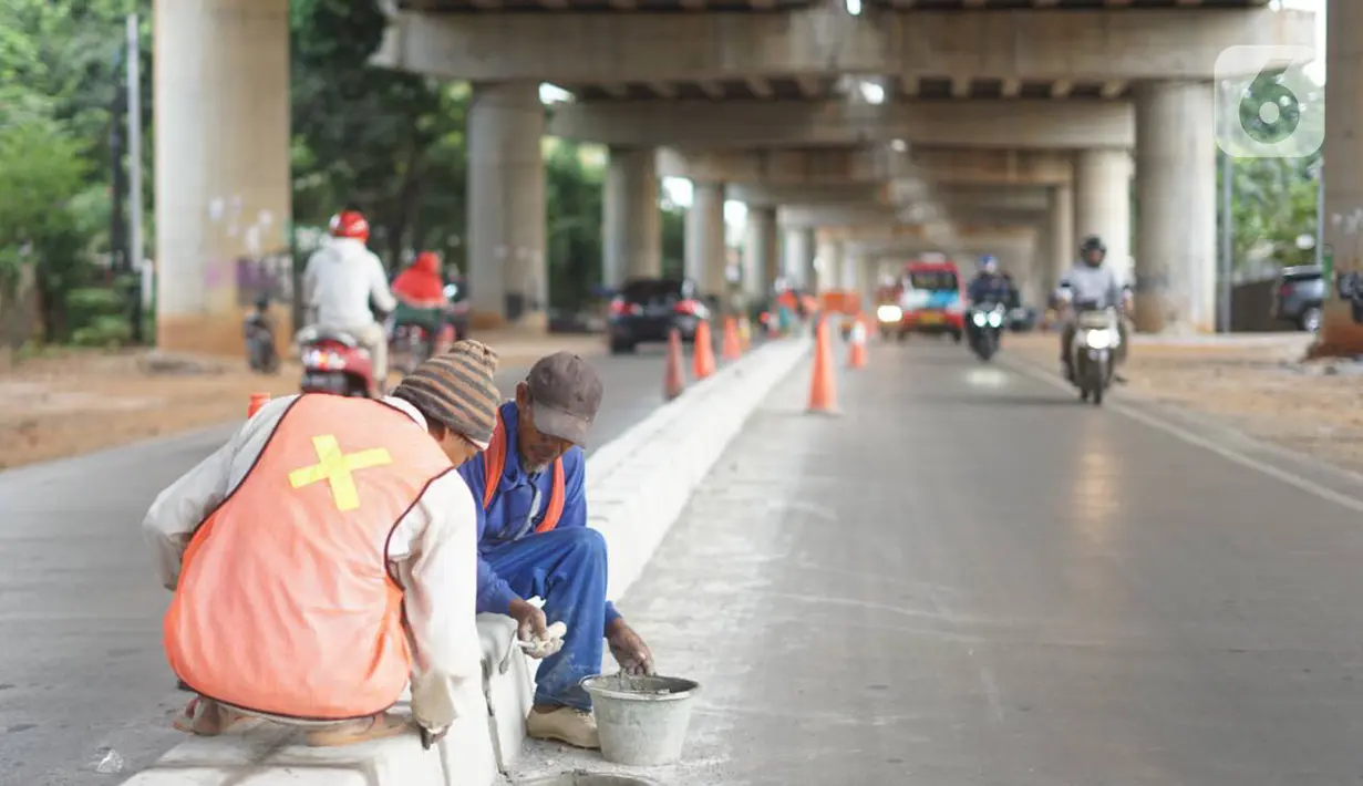 Pekerja menyelesaikan pembuatan separator atau pembatas jalan di Jalan Margasatwa, Andara, Jakarta Selatan, Kamis (21/11/2019). Separator itu dibuat guna memisahkan dua lajur sehingga meminimalisasi tingkat kecelakaan. (Liputan6.com/Immanuel Antonius)