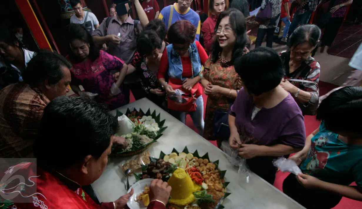 Seorang pemuka umat memotong tumpeng sebagai ungkapan rasa syukur usai berdoa bersama di klenteng poncowinatan,Yogyakarta, (2/6). Klenteng Poncowinatan ini merupakan salah satu Bangunan Cagar Budaya (BCB) yang dimiliki Kota Yogyakarta. (Boy Harjanto)