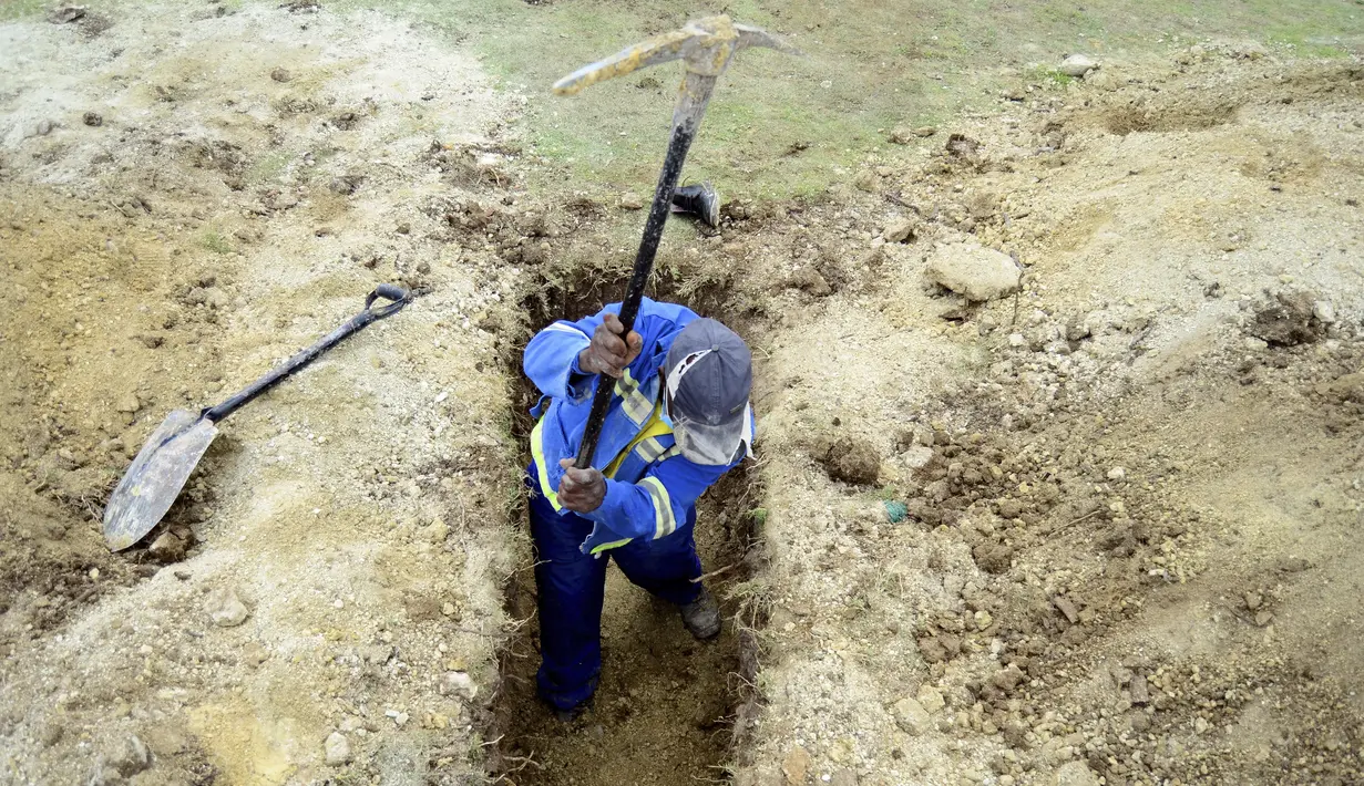 Seorang penggali makam menyiapkan kuburan baru di Pemakaman Motherwell di Port Elizabeth, Afrika Selatan pada 4 Desember 2020. Menteri Kesehatan Afrika Selatan, Zweli Mkhize pada Rabu (9/12/2020) mengumumkan negara itu sekarang sedang mengalami gelombang kedua Covid-19. (AP Photo/Theo Jeftha)