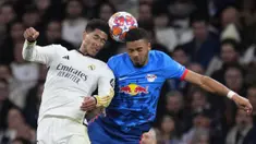 Pemain Real Madrid, Jude Bellingham (kiri) berduel udara dengan pemain RB Leipzig, Benjamin Henrichs pada laga leg kedua 16 besar Liga Champions 2023/2024 di Santiago Bernabeu, Madrid, Spanyol, Kamis (07/03/2024) WIB. (AP Photo/Manu Fernandez)