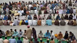 Mereka duduk berbaris dengan rapi dan saling berhadapan. Panjang barisan bisa mencapai 10 meter. Ratusan orang selalu berkumpul hampir setiap hari selama Ramadan, Quetta, Pakistan, Rabu (2/7/2014) (AFP PHOTO/BANARAS KHAN)