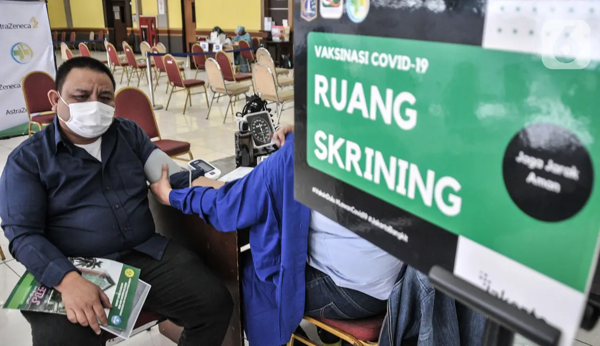 Warga melakukan pemeriksaan kesehatan sebelum menerima vaksinasi Covid-19 dosis kedua di Gelanggang Remaja Pulogadung, Rawamangun, Jakarta, Kamis (18/11/2021). Kementerian Kesehatan mencatat, capaian vaksinasi dosis kedua di Indonesia telah mencapai 86.335.923 orang. (merdeka.com/Iqbal S. Nugroho)