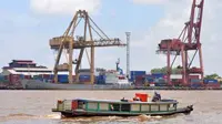 ebuah kapal kayu melintas di depan kawasan bongkar muat peti kemas PT Pelabuhan Indonesia (Pelindo) II Cabang Pontianak di Pelabuhan Dwikora, Pontianak, Kalbar. (Antara)