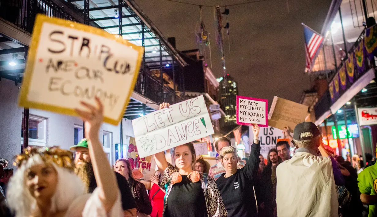 Sejumlah orang membawa poster saat melakukan demonstrasi di Bourbon Street, New Orleans (1/2). Aksi demonstrasi ini dilakukan oleh para penari, pekerja klub malam dan pendukungnya. (AFP/Emily Kask)