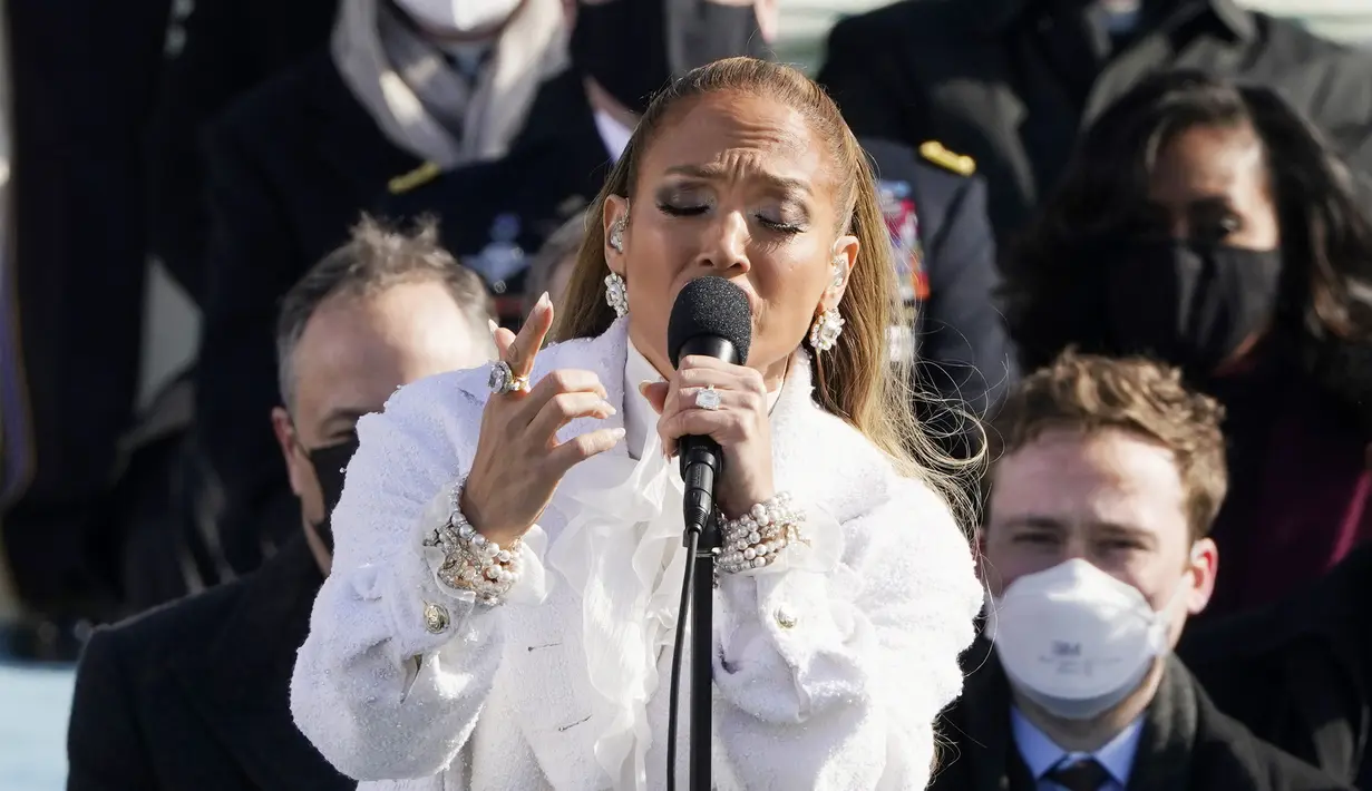 Jennifer Lopez bernyanyi saat pelantikan Presiden terpilih AS Joe Biden di Front Barat Capitol AS di Washington, DC (20/1/2021). Wanita yang akrab disapa JLo itu menyanyikan dua lagu sekaligus, "This Land is Your Line" dan "America the Beautiful".  (Patrick Semansky/Pool/AFP)