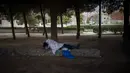 Seorang tunawisma tidur di taman umum di Barcelona, Spanyol, Selasa (9/2/2021). Lonjakan jumlah kasus harian yang terjadi sejak Oktober 2020 meningkatkan jumlah kumulatif kasus virus corona di Spanyol melampaui 3 juta dengan 60 ribu kematian.  (AP Photo/Emilio Morenatti)