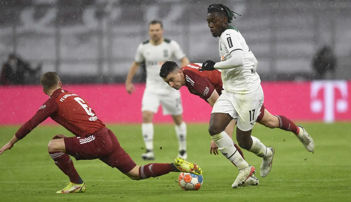 Bek Bayern Munchen Joshua Kimmich (kiri) berebut bola dengan gelandang Borussia Monchengladbach, Manu Kone (kanan) pada laga pekan ke-18 Bundesliga di Allianz Arena, Sabtu (8/1/2022) dini hari WIB. Bayern Munchen dipermalukan di kandang sendiri 1-2. (AP Photo/Andreas Schaad)