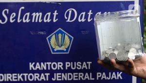 Massa melakukan aksi simbolik 'Koin Peduli untuk Ditjen Pajak' di depan Kantor Di depan Kantor Direktorat Jendral Pajak, Senayan, Jakarta Selatan, Kamis (3/3/2023). Aksi koin peduli ini digelar sebagai wujud kekecewaan karena bobroknya birokrasi lembaga keuangan dan perpajakan saat ini. (Liputan6.com/Herman Zakharia)