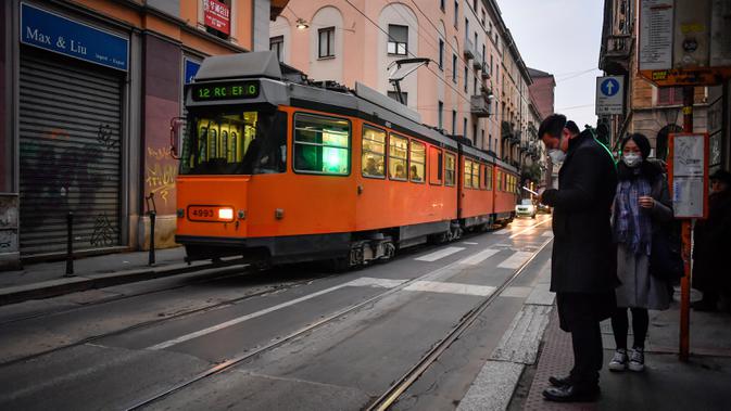 Aktivitas warga di sebuah jalan di pusat Kota Milan, Italia, Selasa (25/2/2020). Warga banyak mengurangi aktivitas di luar rumah terkait virus corona atau COVID-19 di Italia. (Claudio Furlan/LaPresse via AP)