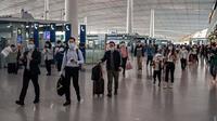 Orang-orang tiba di Bandara Internasional Ibu Kota Beijing untuk melakukan perjalanan menjelang liburan "Golden Week" pada 30 September 2020. Gelombang liburan melanda China yang warganya merayakan libur panjang, yang dikenal dengan Golden Week. (NICOLAS ASFOURI / AFP)