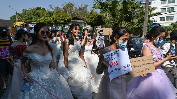 Wanita Myanmar memakai gaun pengantin memegang plakat selama demonstrasi menentang kudeta militer 1 Februari di Yangon (10/2/2021). (AFP/ Ye Aung Thu)