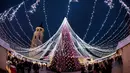 Orang-orang berjalan di sekitar pohon Natal raksasa yang berdiri di Alun-Alun Katedral di Vilnius, Lithuania, 5 Desember 2017. Karena keindahannya, pohon Natal tersebut menjadi salah satu pohon Natal terindah di dunia. (AP Photo/Mindaugas Kulbis)