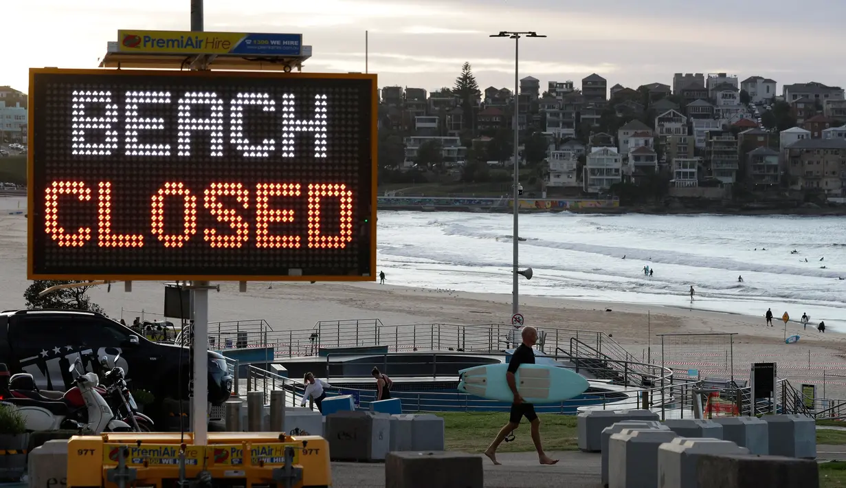 Tanda menunjukkan bahwa pantai ditutup ketika peselancar tiba pada pukul 7 pagi  di Sydney, Selasa, (28/4/2020).  (AP Photo/Rick Rycroft)