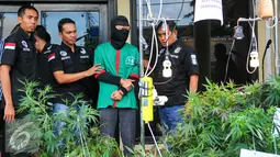 Tersangka DI (37) dihadirkan saat rilis di halaman Polres Jakarta Barat, Rabu (27/4).  Polres Metro Jakarta Barat amankan puluhan pot tanaman ganja serta puluhan gram paket ganja siap edar. (Liputan6.com/Yoppy Renato)