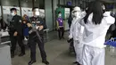 Polisi mengingatkan penumpang untuk memakai pelindung wajah dengan benar di Bandara Internasional Manila, Filipina, Senin (18/1/2021). Infeksi virus corona COVID-19 di Filipina telah melonjak melewati 500 ribu kasus.  (AP Photo/Aaron Favila)