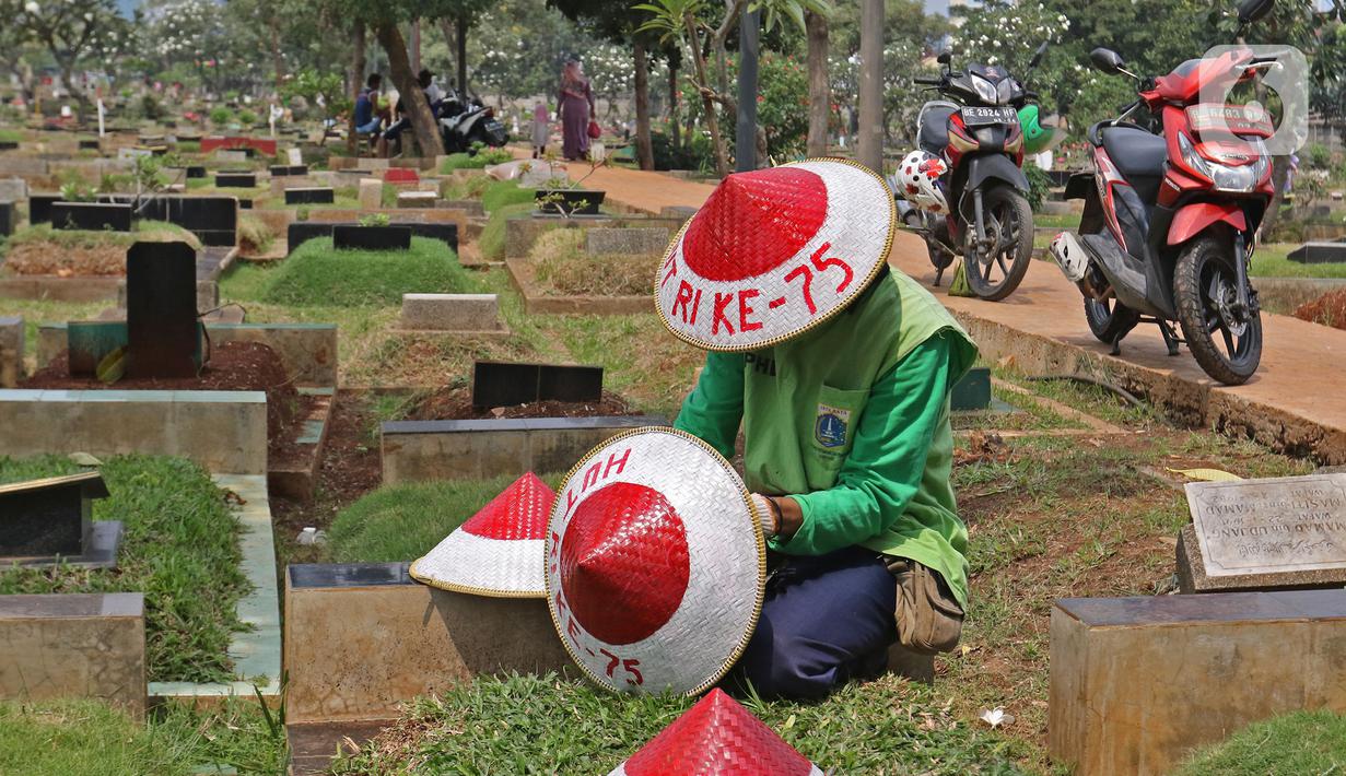 Petugas Pertamanan dan Kehutanan Kota Jakarta Pusat mengenakan atribut kemerdekaan saat menyiapkan caping di TPU Karet Bivak, Jakarta, Minggu (16/8/2020). Para petugas bekerja dengan mengenakan atribut kemerdekaan dalam rangka menyambut HUT ke-75 RI. (Liputan6.com/Herman Zakharia)