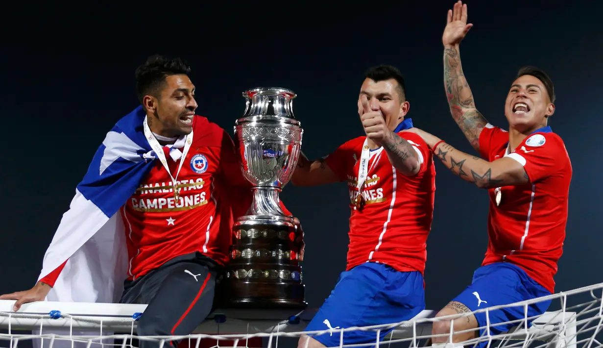 Pemain Chili menaiki gawang membawa trofi merayakan kemenangan usai mengalahkan Argentina di Final Copa America 2015 di Stadion Nasional, Chili, (4/7/2015). Chili menang lewat adu penalti atas Argentina dengan skor 4-1. (REUTERS/Marcos Brindicci)
