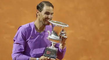 Petenis Spanyol, Rafael Nadal menggigit trofi juara turnamen tenis Italia Terbuka 2021 setelah mengalahkan petenis Serbia, Novak Djokovic di Foro Italico, Roma, Minggu (16/5/2021). Rafael Nadal menang dalam pertarungan tiga set 7-5, 1-6, dan 6-3 selama dua jam 49 menit. (AP Photo/Gregorio Borgia)