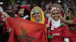 Para fans wanita Maroko tersenyum menunggu dimulainya pertandingan grup F Piala Dunia 2022 antara Kanada dan Maroko di Stadion Al Thumama di Doha, Qatar, Kamis, 1 Desember 2022. (AP Photo/Frank Augstein)