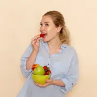 Seorang perempuan sedang makan buah-buahan (Foto Dok: Freepik/KamranAydinov).