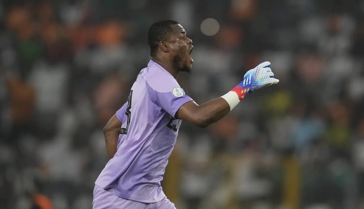 Kiper Nigeria, Stanley Nwabali, melakukan selebrasi setelah berhasil menghalau bola tendangan penalti pemain Afrika Selatan pada laga semifinal di Stade de la Paix, Kamis (8/2/2024). (AP Photo/Themba Hadebe)