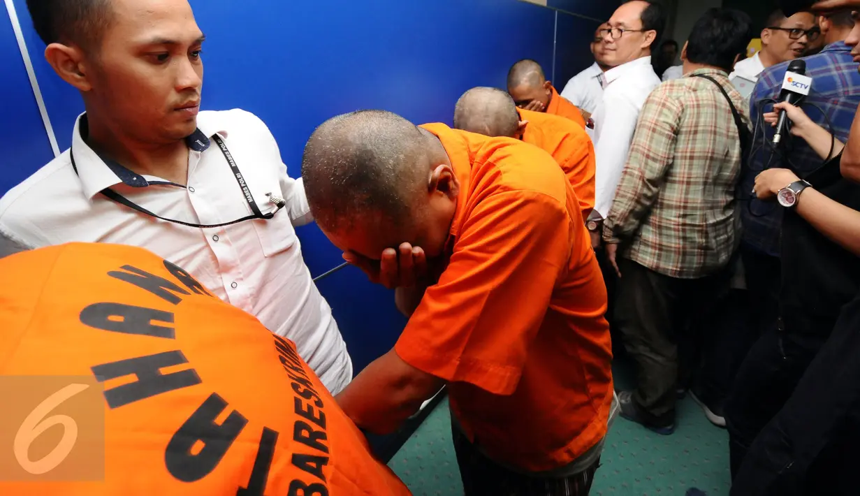 Empat tersangka peredaran uang palsu digiring petugas usai rilis di Bareskrim Mabes Polri, Gedung KKP, Jakarta, Senin (10/10). Peredaran dikendalikan dari rutan. (Liputan6.com/Helmi Fithriansyah)
