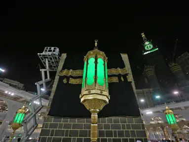 Petugas saat mengganti kain penutup Ka'bah (Kiswah) dengan yang baru di Masjidil Haram, kota suci Makkah, Arab Saudi (18/7/2021). Menjelang puncak ibadah haji 1442 H, petugas Masjidil Haram melakukan penggantian kain penutup Ka'bah lama dengan Kiswah yang baru. (AFP Photo)