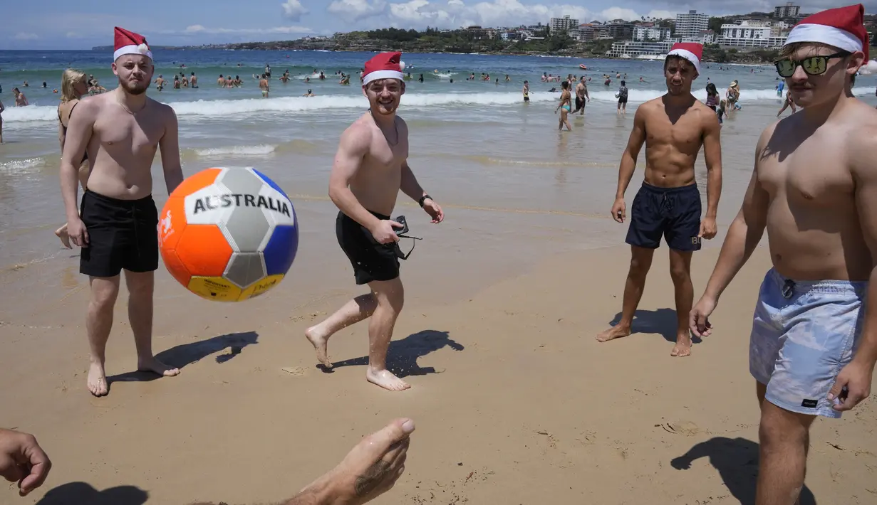 Pengunjung dan penduduk lokal berbondong-bondong ke Pantai Bondi yang ikonik di Sydney untuk menghabiskan waktu bersama keluarga dan teman-teman di Hari Natal.  (AP Photo/Rick Rycroft)