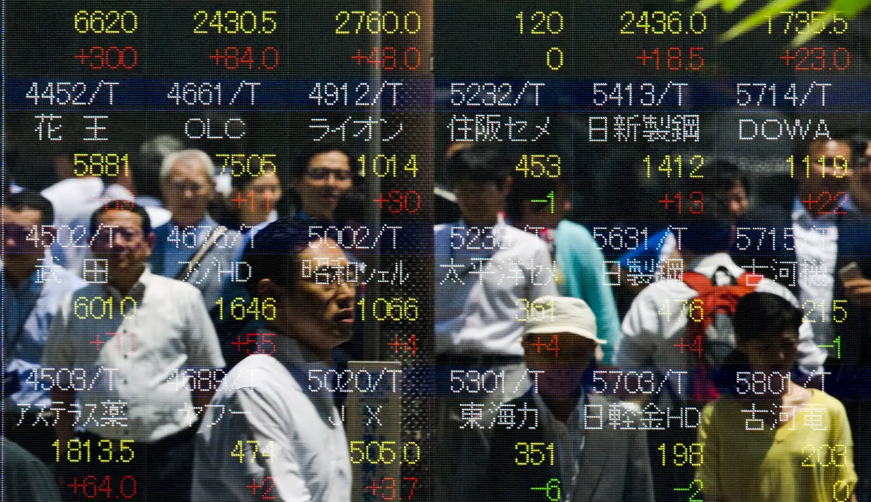 Sejumlah orang tercermin dalam papan yang menampilkan indeks saham di Tokyo, Jepang, Jumat, (10/7/ 2015). Harga saham Nikkei mengalami perubahan mengikuti gejolak pasar Tiongkok. (REUTERS/Thomas Peter)