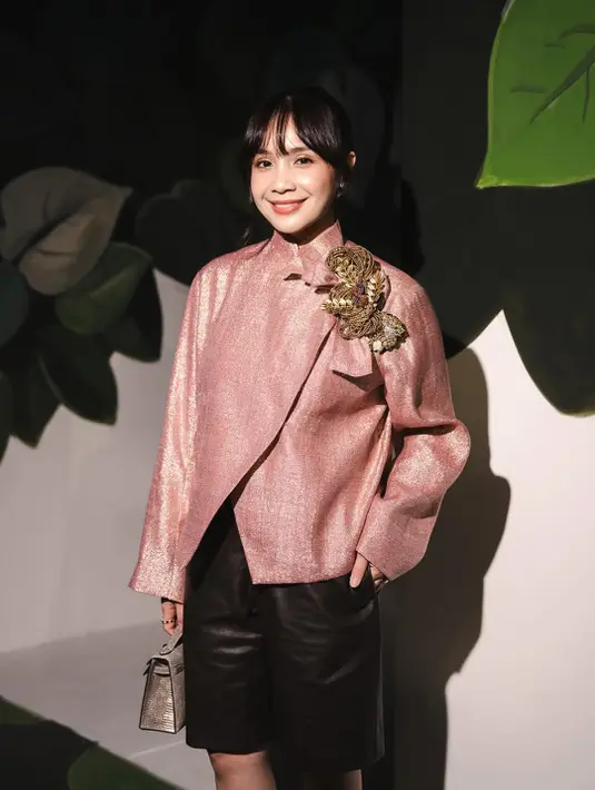 Nagita Slavina tampil chic dengan beskap sequin pink dan embellisment 3D bermotif bunga emas, Dipadu dengan celana pendek leather dan tas Hermes silver [@biyanofficial]