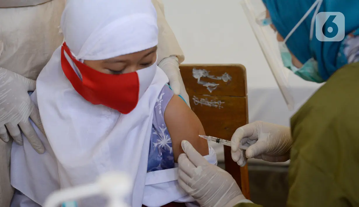 Seorang siswa kelas I mendapatkan imunisasi campak saat pelaksanaan Bulan Imunisasi Anak Sekolah (BIAS) di SDN Serua 3, Ciputat, Tangsel, Selasa (1/9/2020). Kegiatan itu untuk memberikan kekebalan terhadap siswa dari penyakit campak, difteri dan tetanus. (merdeka.com/Dwi Narwoko)